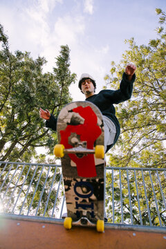 Young skateboarder perform trick at urban skatepark
