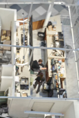 Fototapeta premium Office Cubicles Occupied Employees Working At Desks Inside Open Plan Corporate Workspace Viewed From High Angle With Blurred Focus On Activity.