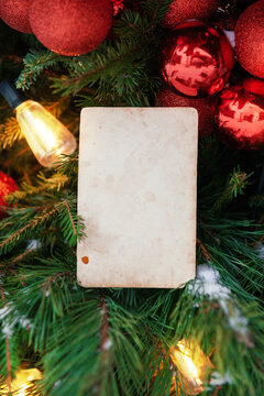 Christmas tree with blank vintage card and red ornaments