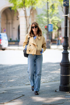 Full length middle-aged blonde woman walking down the street in a European city street