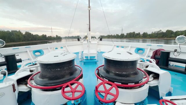 The ship bow navigates down the calm river. A peaceful and exciting feeling fills the air during this scenic voyage.