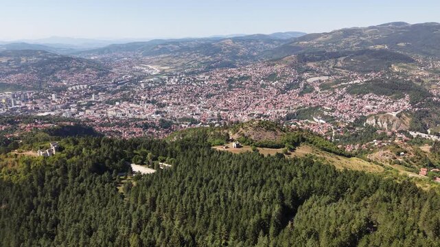 Drone Aerial View Flying From Trebevic Mountain Forest Revealing Panoramic Cityscape View of Sarajevo Valley