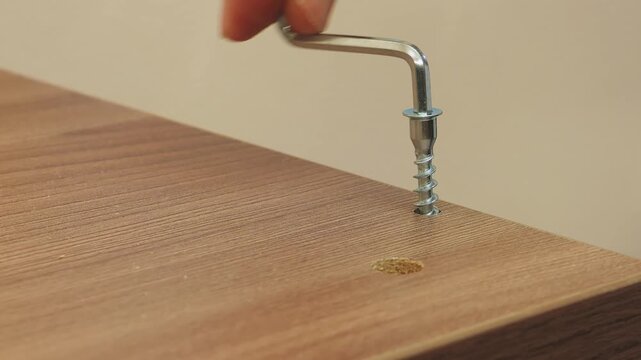 Assembling furniture with drawers using screws and screwdrivers.
