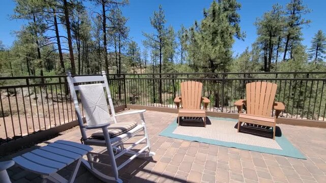 Sunny patio deck with rocking chairs overlooking pine trees
