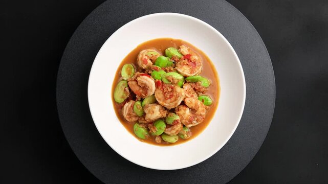 Stir fried Stink Beans(Bitter Beans) with Shrimp Paste and Fresh Prawns in white plate.Top view.