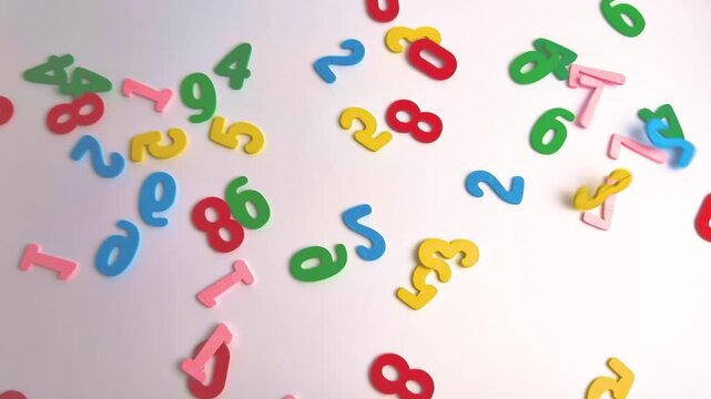 Colorful wooden number pieces fall onto white background bounce naturally Playful movement Bright educational representing counting early childhood learning preschool education playful mathematics