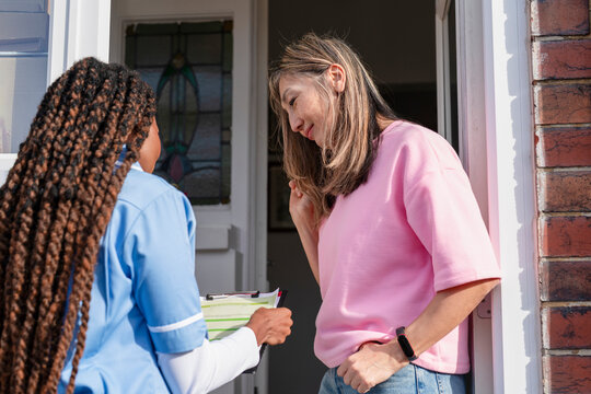 Healthcare worker visits a home to provide support and assistance to woman in a suburban neighborhood