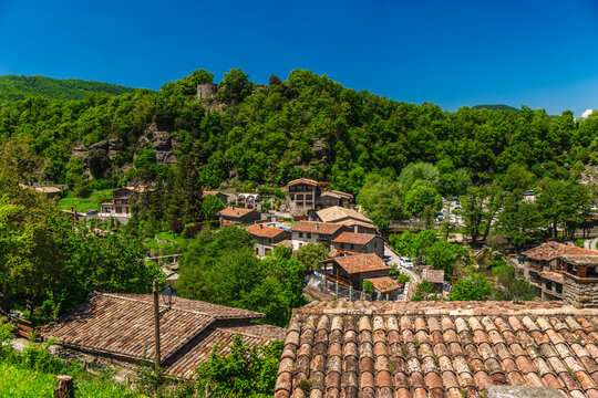 Panoramic view of Rupit village rooftops surrounded by forested hills in Catalonia, Spain, scenic rural landscape with traditional stone houses