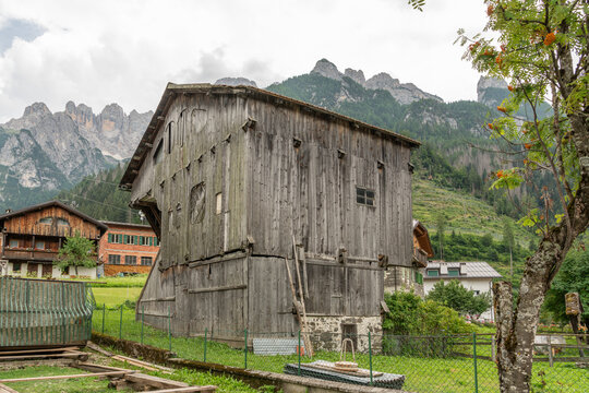 Alleghe, Italy. Historic Alpine wooden barn with Dolomite mountain backdrop