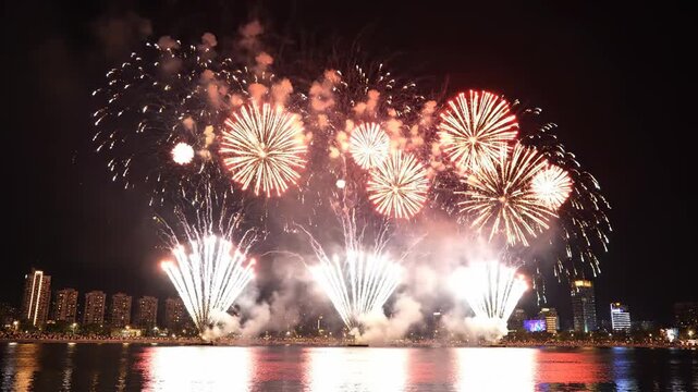 Fireworks exploding over waterfront city skyline during nighttime celebration video firework pyrotechnics explosion night