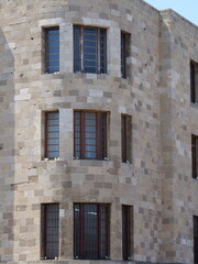 Fototapeta premium Symmetric curved brick wall architecture with dark window frames