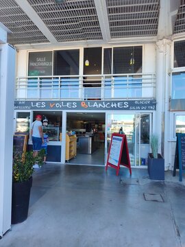 Royan, France - May 31, 2026: Charente-Maritime. Nouvelle-Aquitaine. Entrance of Les Voiles Blanches cafe with outdoor seating and menu board, modern architecture in a coastal setting