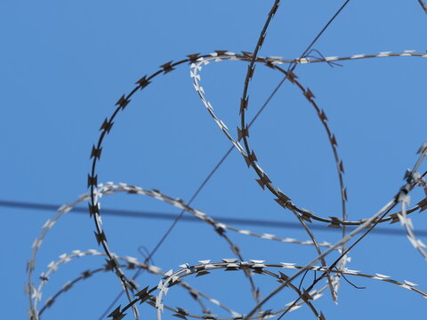 Razor wire border fence symbolizing refugee crisis and migration