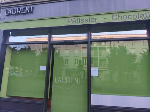 Royan, France - May 31, 2026: Charente-Maritime. Nouvelle-Aquitaine. Laurent Patissier - Chocolatier storefront with green awning and large glass windows in urban setting