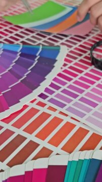 Color selection process with paint swatches and hands at a design studio
