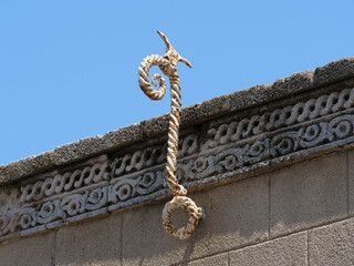 Ornate wrought iron wall anchor on a historic stone building © Christian Bunge