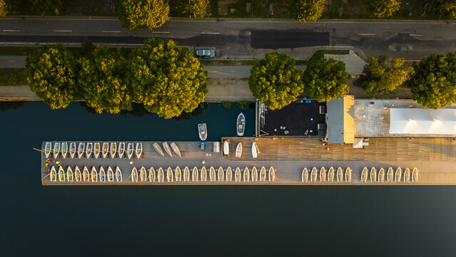 Aerial view of the Charles River Esplanade with rows of rowing shells docked at the pier during golden hour in Boston, Massachusetts, United States.