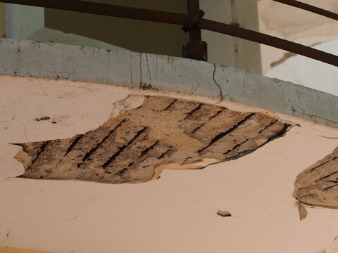 Concrete spalling and exposed rusted rebar on a building balcony