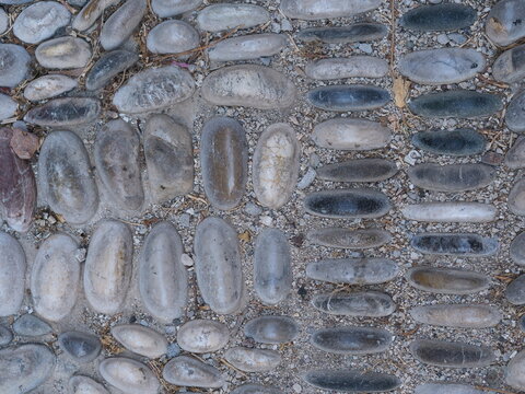 texture of a traditional Greek chochlakia pebble mosaic pavement with repeating patterns.