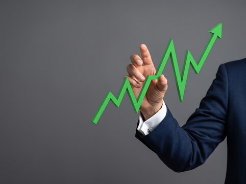Businessman pointing to growing graph with green arrow