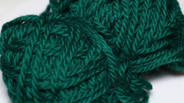 A close-up of a piece of green yarn, perfect for crafting and DIY projects. Rotating in a circle