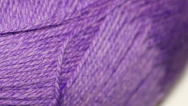 A close-up of a purple yarn ball. Rotating in a circle