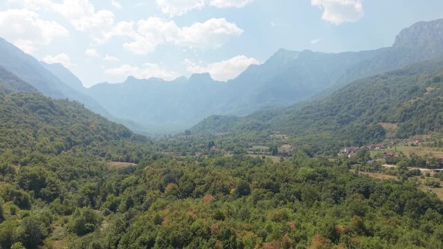 Drone Aerial View Flying Over Dense Forest Canopy Towards Massive Rocky Peaks of Prenj Mountain