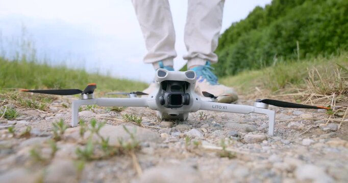 Close-up of compact drone behind take-off. Ground level view