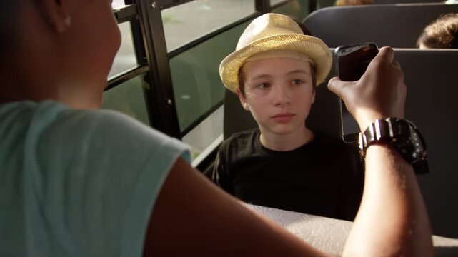Iconic school bus driving kids to school and class - kids on smart phones