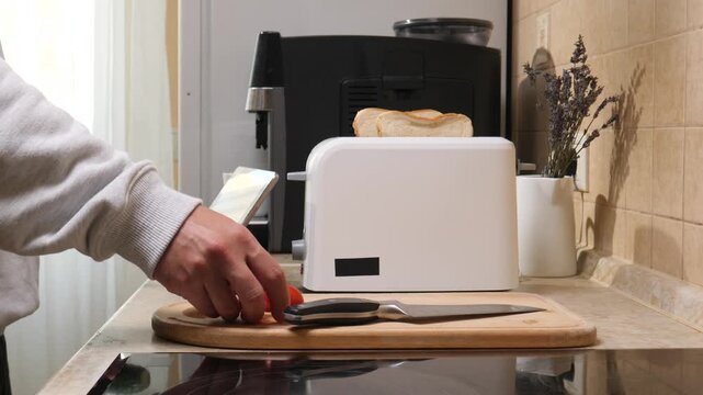Person preparing fresh vegetables for a healthy breakfast in a modern kitchen, using a digital tablet for guidance while toast is warming in the toaster