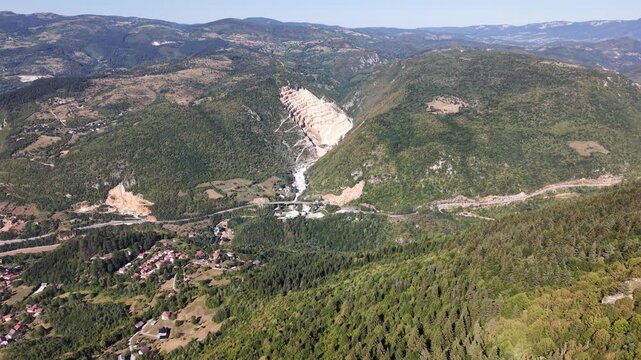 Drone Aerial View Looking from Trebevic Mountain Towards Open Pit Quarry in Mountainous Forest Valley