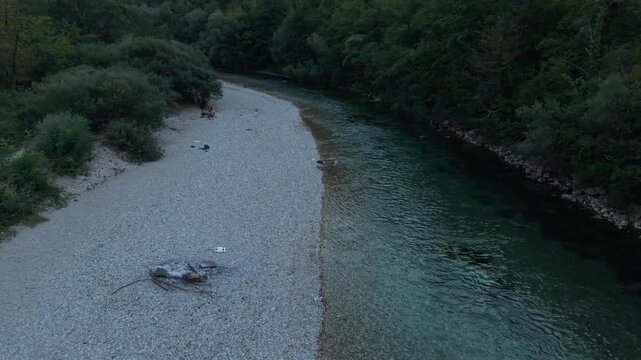 Drone Aerial View Flying Over Neretva Riverbank with Wooden Suspension Footbridge surrounded by Forest