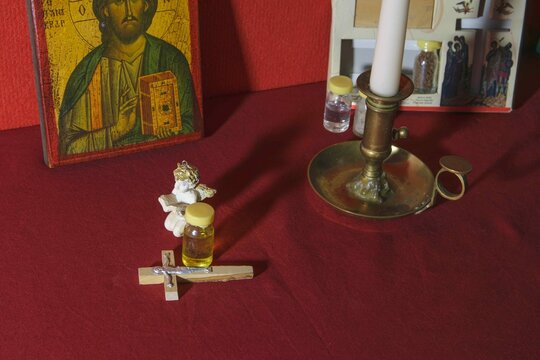 Table setup with religious items and a candle in a simple indoor space Various objects for prayer of the Christian faith