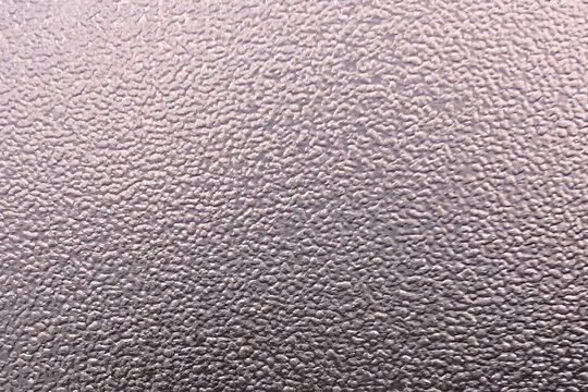 Surface texture close-up showing detailed patterns and colors under soft lighting in an indoor setting - matte film as a background