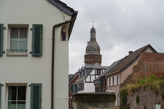 Historic houses line a narrow street leading toward a Juddeturm tower in Zons