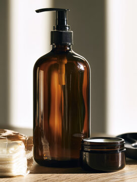 Amber pump bottle still life with cosmetic jar and folded cloth in warm sunlight