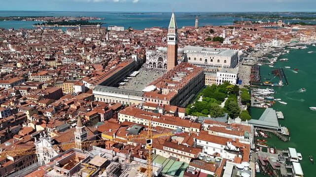 Venice, Italy. Aerial 4K panoramic drone view of the city. Majestic sunny view of the ancient city skyline with channels, Palazzo Ducale, St Mark's square and other iconic buildings. Europe from above