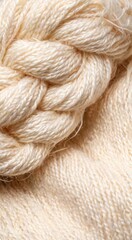 Fototapeta premium Close-up of a braided natural fiber rope on a soft beige fabric background. The texture is smooth and inviting, showcasing craftsmanship and material quality.