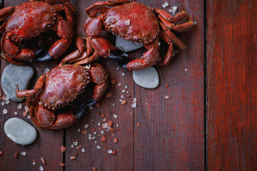 Fresh cooked crabs on rustic wooden background with sea salt crystals and stones, nutritious seafood rich in protein for healthy eating and balanced diet © svittlana