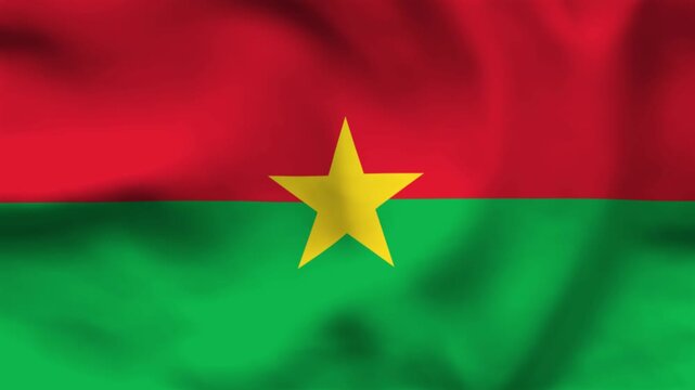 Burkina Faso flag on wavy fabric, top view. Realistic red and green textile texture featuring a central yellow star emblem.