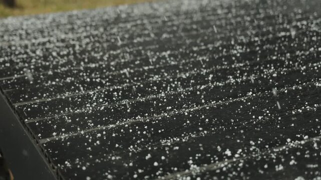 Light first snow falling on a dark roof surface during cold winter weather outdoors.