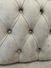 Naklejka premium Tufted beige leather upholstery with diamond pattern, suitable for texture or interior design background