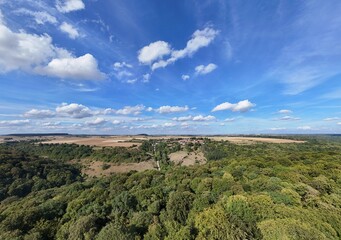 Obraz premium Vue panoramique aérienne en campagne, avec des champs labourés et une forêt après la canicule, fin août 2026, les arbres virent aux couleurs d'automne en France