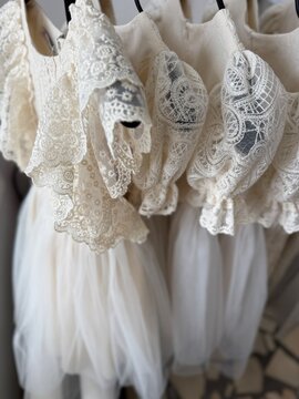 Lace wedding dresses with intricate details hanging on a rack