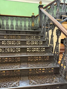 Ornate wrought iron staircase with detailed railing design in historic building interior