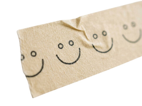 Piece of brown masking tape with smiling faces isolated on transparent background