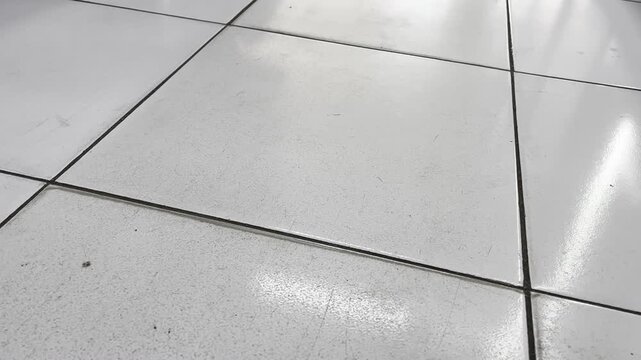 Clean glossy white ceramic tiles floor with bright light reflection
