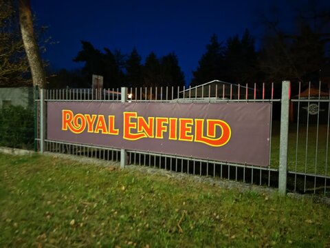 Plzen,Czech Republic-11 April 2026:Royal Enfield banner outside motorcycle dealership, night view