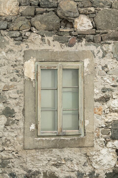 Alleghe, Italy. Weathered stone wall with rustic wooden window