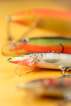 Colorful fishing lures with scale pattern on yellow background The Concept of angling and hobby